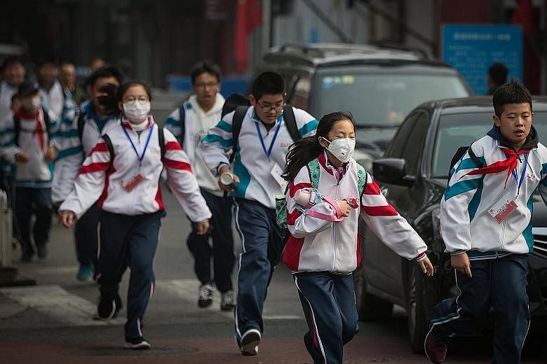 Some students wearing masks as protection against the polluted air last Friday in Beijing, China. As the world's top emitter of greenhouse gases, China has said it aims to bring an overall decline in carbon emissions from 2030. A national cap-and-tra