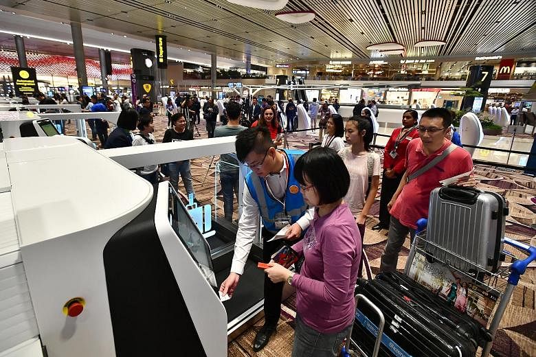 Passengers from Cathay Pacific CX650, the inaugural flight to depart from Terminal 4, using the automated bag drop yesterday. Passengers from Cathay Pacific CX659 from Hong Kong, the first flight to arrive at Terminal 4, were greeted by airport staff