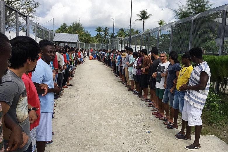 Refugees linking hands in solidarity ahead of the closure of the Manus Island detention centre in Papua New Guinea yesterday. Canberra has insisted that the detainees are not welcome in Australia.