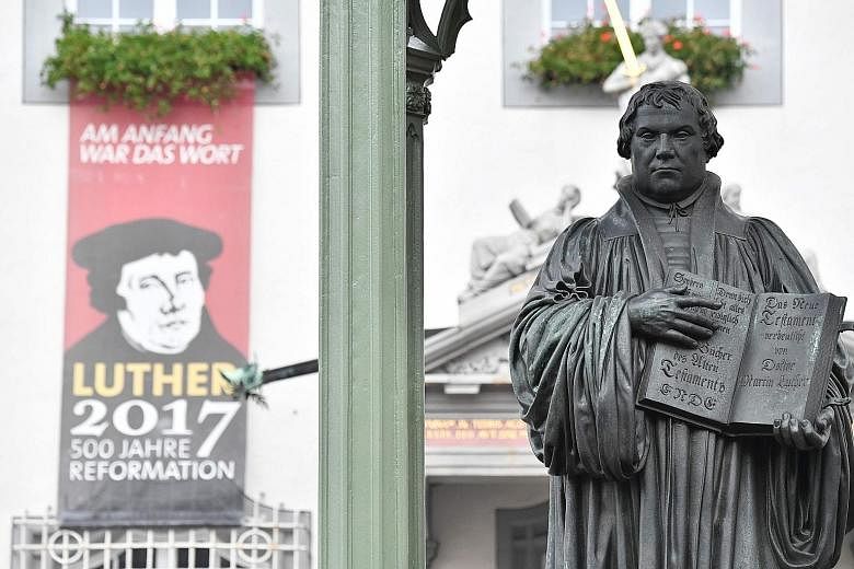 A statue of theologian Martin Luther in Wittenberg. German Chancellor Angela Merkel and President Frank-Walter Steinmeier yesterday attended a service at the church where Luther is said to have first displayed his list of criticisms of the Catholic C