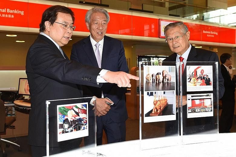 Deputy Prime Minister Teo Chee Hean (centre) viewing one of the displays at the public exhibition on Wind Behind The Sails: The Story Of The People And Ethos Of OCBC with OCBC Bank chairman Ooi Sang Kuang (right) and OCBC Bank Group CEO Samuel Tsien.