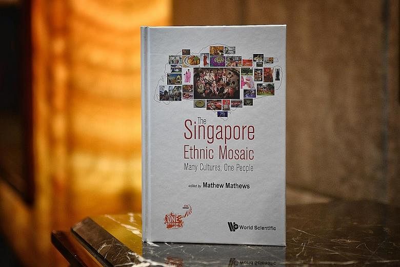 Prime Minister Lee Hsien Loong chatting with facilitators and mentors from OnePeople.sg at its 10th anniversary dinner last night. He also launched a commemorative book (above) featuring various sub-ethnic groups in Singapore.