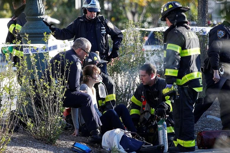 Above: The scene of the attack, in which a man drove onto a bicycle path in New York on Tuesday, mowing down anyone in his path. Below: Emergency personnel giving first aid to a woman who was injured during the attack.