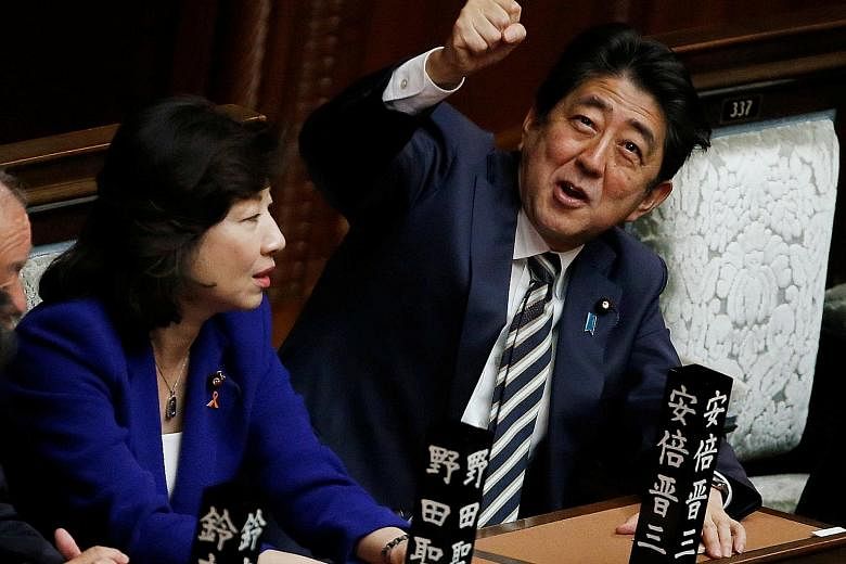 Prime Minister Shinzo Abe gesturing as he talks to Liberal Democratic Party lawmaker Seiko Noda at the Lower House in Tokyo yesterday.