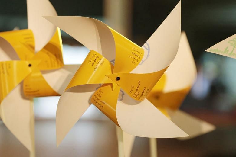 Pinwheels bearing messages from participants at the arts event. People were asked to write down what would make it easier for them to accept death. Volunteer Angeline Cheong in a discussion with some people in the audience. She said death can be a le