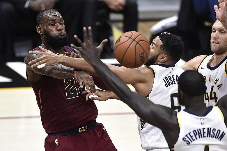 Cleveland forward LeBron James making a pass as Indiana players Cory Joseph, Lance Stephenson and 	Bojan Bogdanovic attempt to block him in their game at Quicken Loans Arena. He led the Cavs with 33 points and 11 assists but committed a game-high eig