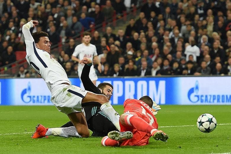 Top: Tottenham's Dele Alli getting to the ball first for Tottenham to open accounts against Real Madrid in their Champions League match at Wembley on Wednesday night. Above: The expressions on the faces of Real's Toni Kroos and Cristiano Ronaldo duri