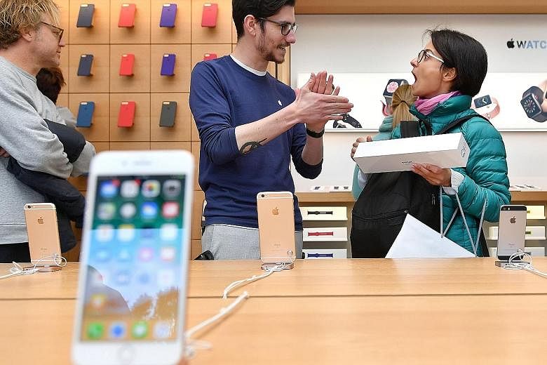 A customer shopping at an Apple store in San Francisco. Apple said it sold 46.7 million iPhones in the fourth quarter ended Sept 30, above analysts' estimates of 46.4 million. Analysts have been eager to see whether Apple can meet demand for the iPho