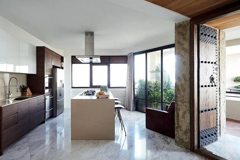 The kitchen island (above) is where the friends of Mr Richard Lee (left) and his wife gather over drinks and to take in the panoramic views of the sea. With the new layout, the space now flows seamlessly to the living and dining areas (right).