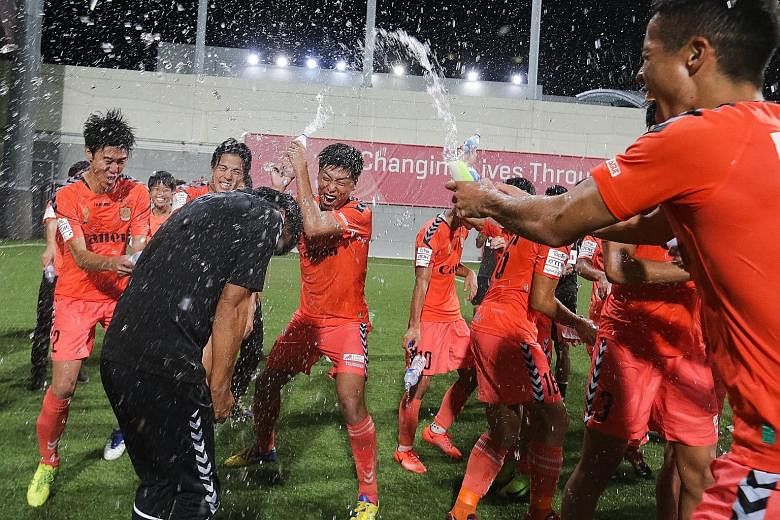 Albirex Niigata coach Kazuaki Yoshinaga being sprayed with water by his players as the White Swans celebrate retaining the S-League title with a 5-1 win over Warriors FC.