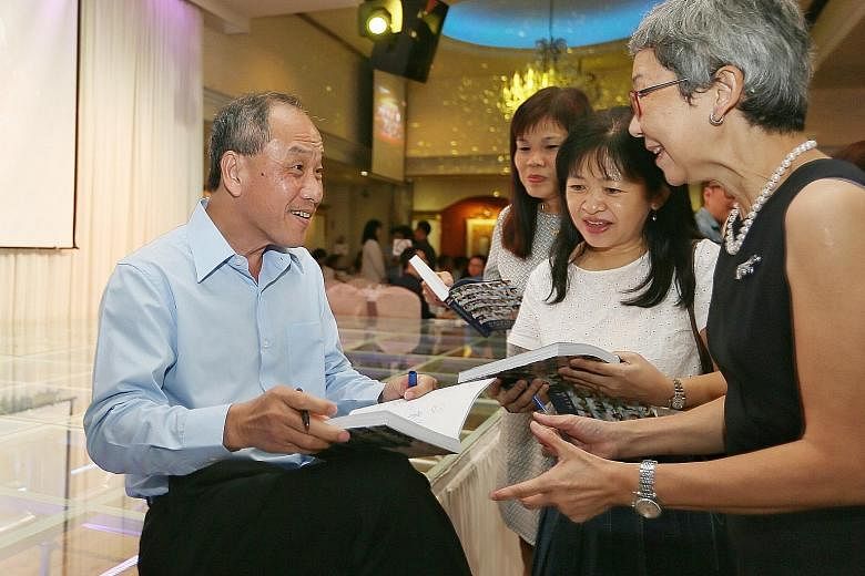 WP secretary-general Low Thia Khiang signing copies of the party's 60th anniversary commemorative book, Walking With Singapore, at the celebratory dinner last night. Mr Low, who entered politics in 1988, would have led the party for 17 years when he 