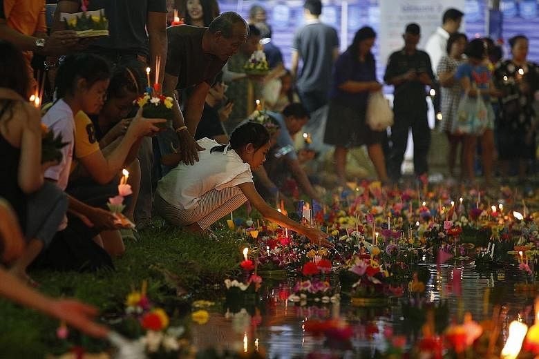 By the light of a full moon on Friday to celebrate Loy Krathong, Thais gathered with friends and family to release flower-shaped floats into canals, rivers and lakes, in a symbolic liberation from past negativity and transgressions.