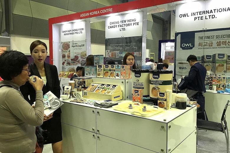 A visitor tasting coconut coffee at Owl's booth at the Asean Trade Fair held in Seoul, South Korea, last week.