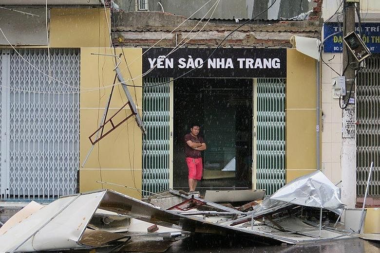 A man surveying the debris from a damaged house in Nha Trang after Typhoon Damrey made landfall in southern Vietnam yesterday. At least six people are missing, said the government.