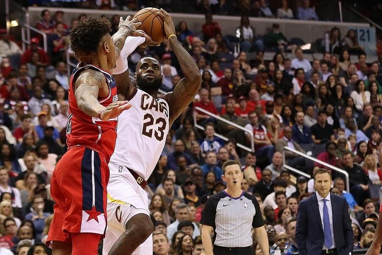 Cleveland Cavaliers forward LeBron James going for a shot despite the close attention of Washington Wizards forward Kelly Oubre Jr at Capital One Arena. The Cavaliers won 130-122, as James came just four points short of his career-best score.