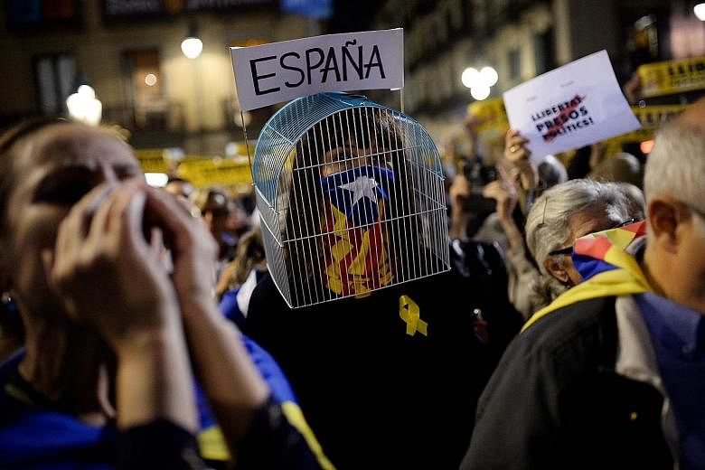 A "caged" woman, her face partly covered with a Catalan flag, taking part in a protest against the detention of former members of the regional government in Barcelona last Friday.