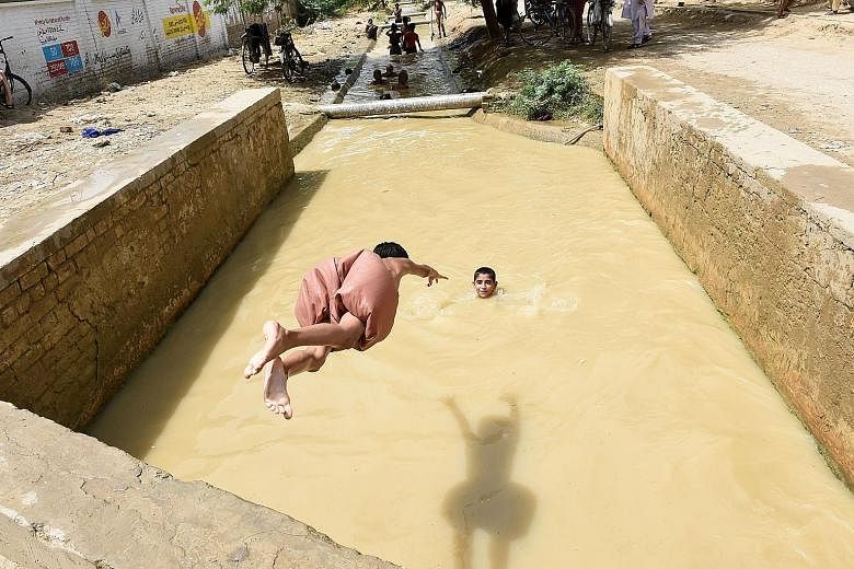 Taking a dive on a hot August day in Sibi, Pakistan, where temperatures hit a sweltering 52.4 deg C this summer. Over the past 115 years, global average temperatures have risen by about 1 deg C, according to the climate report approved for release by