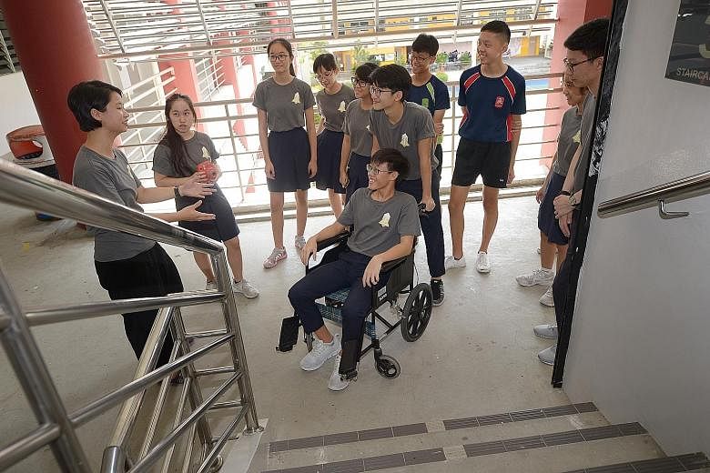 Ms Loh Yuh Yiing (far left), 27, a policymaker, using a wheelchair to demonstrate to her "apprentices" - a group of students from Xinmin Secondary School - the importance of designing inclusive policies. This was part of a workshop organised by The A
