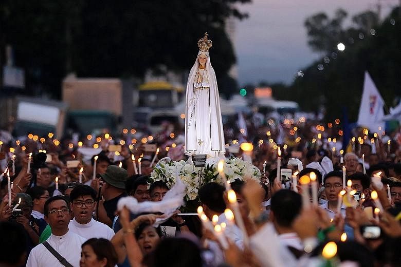 People paying tribute to victims of the anti-drug campaign at the People Power Monument in Quezon city, east of Manila, yesterday. About 3,000 people attended a mass and procession along a historic Manila highway organised by the Catholic Church.