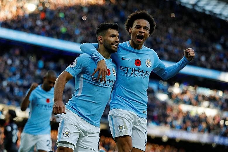 Top: Manchester City's Sergio Aguero (left) celebrates with Leroy Sane after scoring his side's second goal in the 3-1 win against Arsenal yesterday. Above: Gabriel Jesus scores the third goal for City from a cross from David Silva, who was offside d