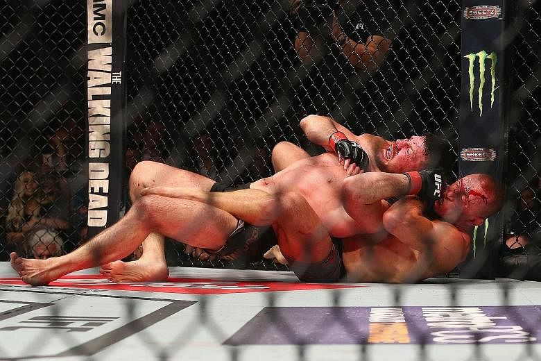 Georges St-Pierre beating Michael Bisping by submission via a rear-naked choke in the third round of their middleweight title bout at UFC 217 at Madison Square Garden on Saturday. He was returning to the combat sport after a four-year absence.