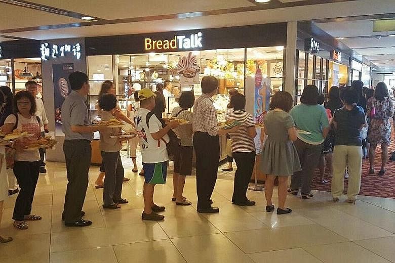 Customers queueing at a BreadTalk outlet. Revenue at BreadTalk dipped 2 per cent for the three months to Sept 30, but the bottom line was boosted by a 7.1 per cent decrease in distribution and selling expenses for the quarter to $59.3 million from $6