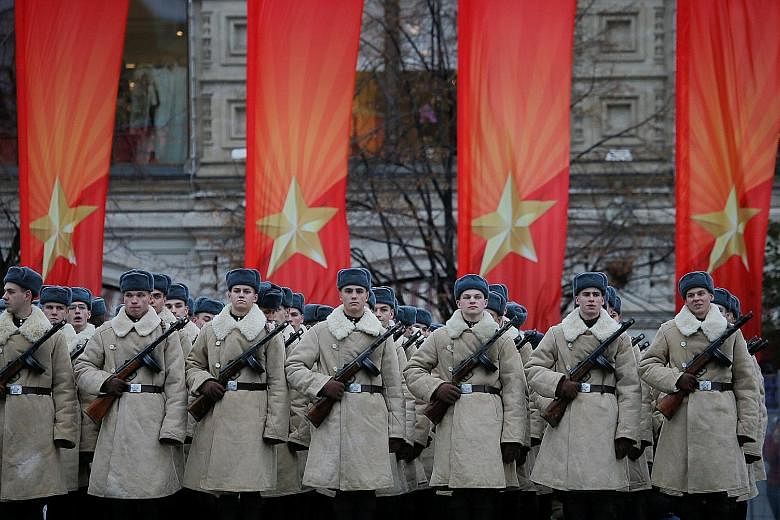 Servicemen dressed in historical uniforms at a military parade in Moscow's Red Square yesterday. The parade was billed as a re-enactment in vintage uniforms of a historic 1941 parade during World War II.