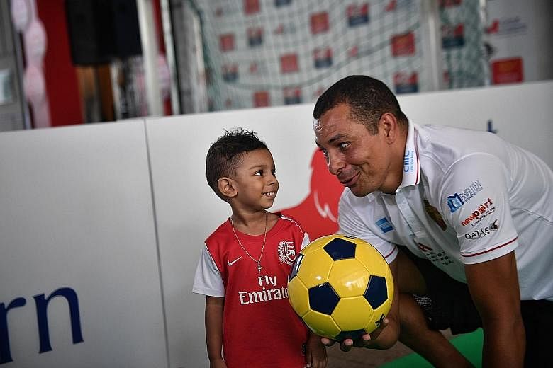 Two-year-old Arthur Zachary with former Arsenal and Brazil player Gilberto Silva at the Score For Charity event yesterday.