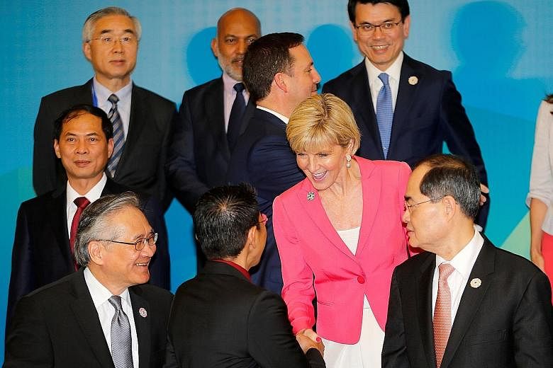 Representing Singapore at the Apec ministerial meeting were Mr Lim Hng Kiang (far right) and Dr Maliki Osman (seen here greeting Australia's Foreign Minister Julie Bishop).