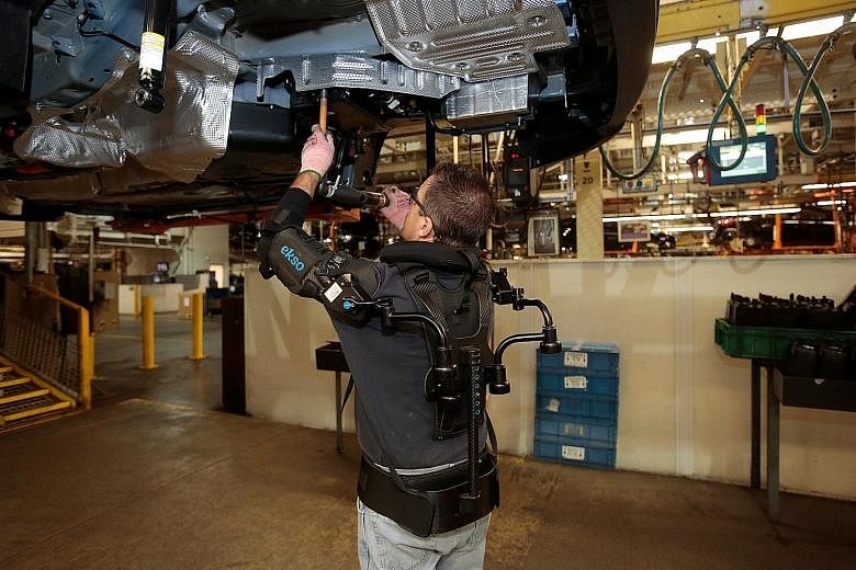 Ford Motor worker Paul "Woody" Collins wears an EksoVest, which takes the stress off his shoulders when performing overhead tasks.