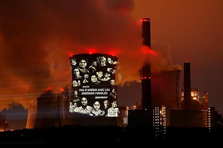 A light projection that reads "No future with fossil energies" in French on the facade of a coal-fired power plant in Germany. The Paris Agreement calls on the world to cap global warming at "well below" 2 deg C.