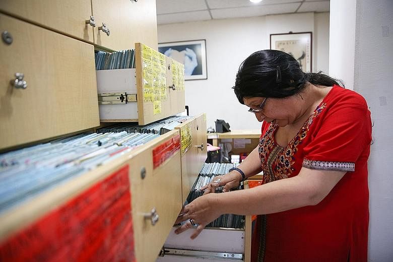 Clinic assistant Devi Bhattacharjee, 51, combing through Dr Lee's patient records. They are held in more than 10 groaning drawers - each the size of a microwave oven. Said Dr Lee: "Every year, our drawers get heavier and every few years, we have to u