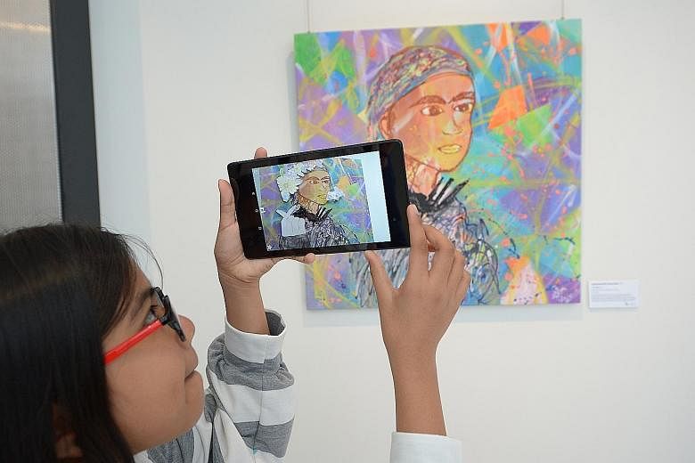 The Little Arts Academy student Nashariyah Shamsudin, 11, showing off her work Fun Vines, which includes an element of "augmented reality", at the centre's Northpoint City campus launch yesterday. The academy provides free arts training for beneficia