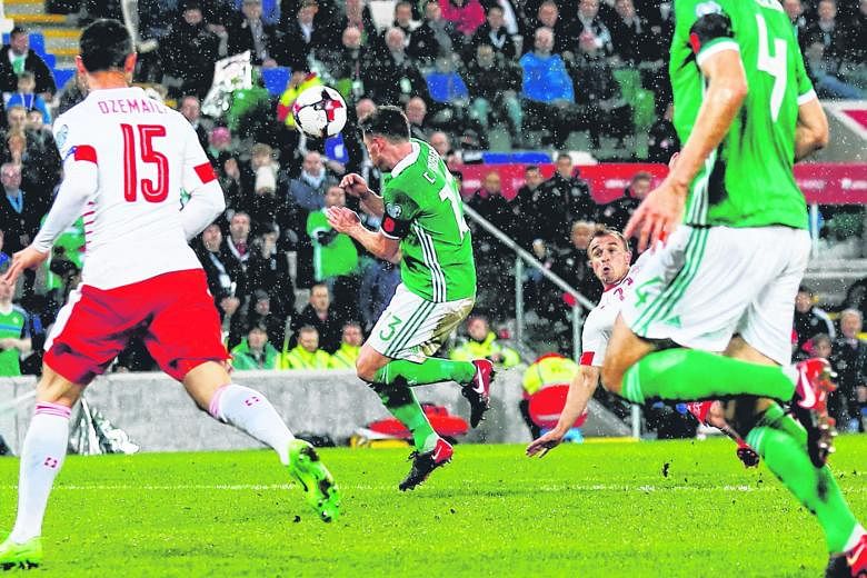 A shot by Switzerland's Xherdan Shaqiri hits Northern Ireland's Corry Evans on Thursday, leading to a contentious penalty for handball.