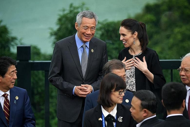 PM Lee Hsien Loong and New Zealand PM Jacinda Ardern at a group photo for leaders yesterday. With them are (from left) Japanese PM Shinzo Abe, South Korean President Moon Jae In (partly hidden) and Malaysian PM Najib Razak.