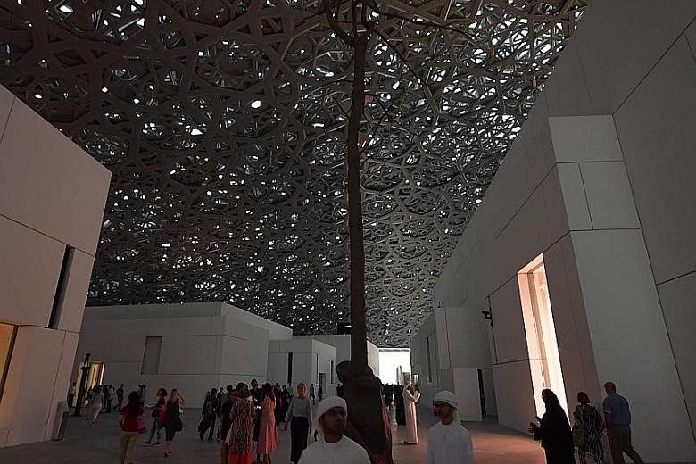 Visitors walk past a piece of art titled Germination by Italian artist Giuseppe Penone at Louvre Abu Dhabi.