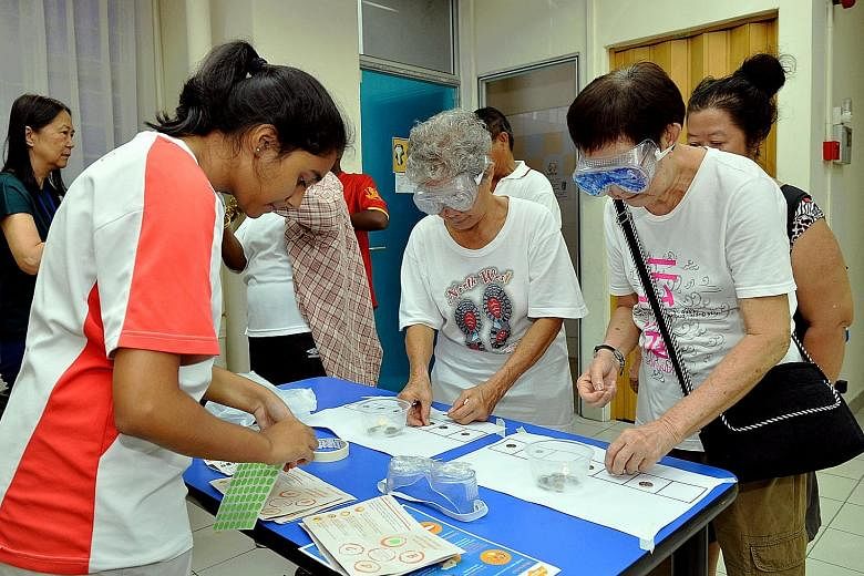 At the "Walk With Me: Our Journey Of Remembering" event in Nee Soon South yesterday, about 100 participants performed daily tasks such as buttoning a shirt and sorting coins while wearing gloves or goggles. The idea was to give them a sense of the ch