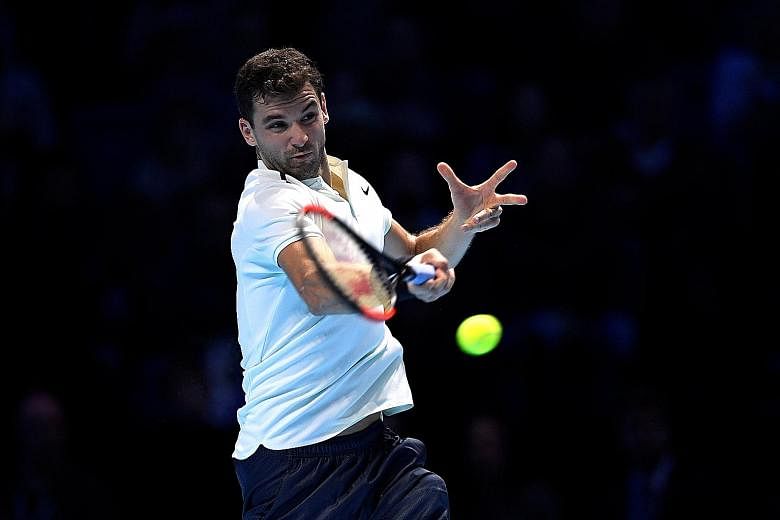 Grigor Dimitrov of Bulgaria hits a forehand during his 6-3, 5-7, 7-5 ATP Tour Finals victory over Dominic Thiem of Austria yesterday. He squandered two match points when serving for the match but clinched the third.