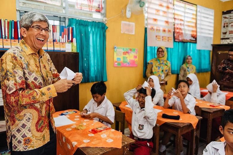 Dr Yaacob Ibrahim taking part in origami storytelling at one of the Yogyakarta schools in the Words on Wheels initiative.