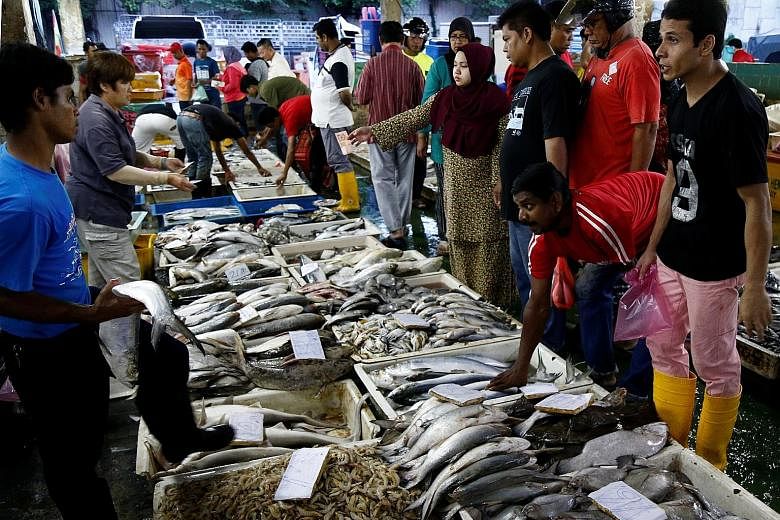 Customers selecting seafood at a wet market in Klang, outside Kuala Lumpur, on Oct 27. Ms Jeanne Khor, secretary of the Pantai Remis Fishermen Association, said the rainy season could cut the catch by 50 to 60 per cent.