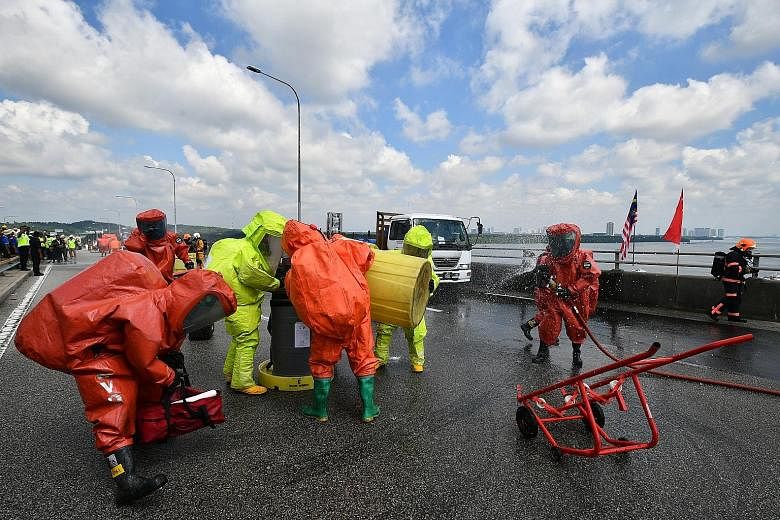 A car carrying a prominent businessman and three passengers "collided" with a truck carrying 20 drums of hydrochloric acid - resulting in five of the drums falling onto the road and leaking. One drum "fell" into the waters below, though it remained s