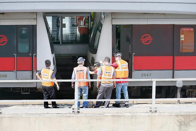 SMRT officials examining the two trains which had collided yesterday morning. The signalling system had mistakenly profiled the stalled vehicle as a three-car train instead of the six-car train that it was. As a result, a second train behind the firs