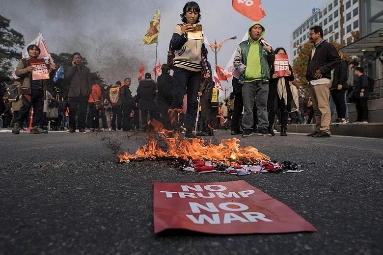 Anti-Trump protesters burning a US flag during a rally outside the National Assembly, where Mr Donald Trump was speaking, in Seoul on Nov 8. Before his visit, there were fears that he would threaten to rain down fire and fury once more on North Korea