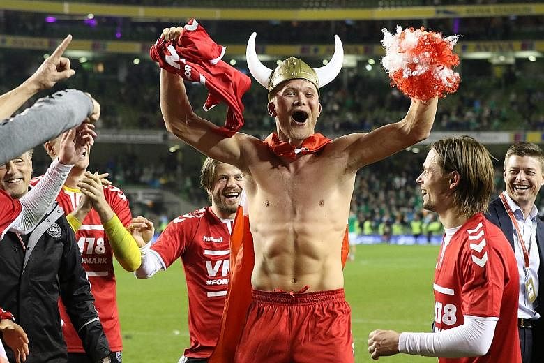 Left: Danish striker Andreas Cornelius, replete with viking helmet, leading his team's celebrations after their 5-1 aggregate win over Ireland. Below: Christian Eriksen scoring his first and Denmark's second en route to a classy hat-trick. The Dane's