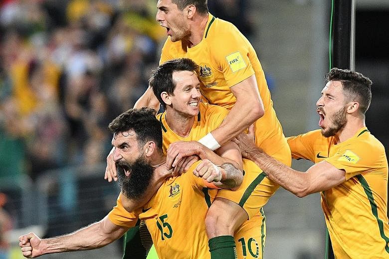 Australia skipper Mile Jedinak (bearded) carrying team-mates Robbie Kruse and Tomi Juric, and his country's World Cup hopes after scoring against Honduras.