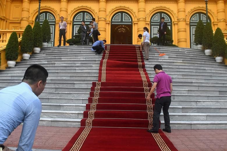 Workers preparing for US President Donald Trump's state visit to Hanoi on Sunday. His visit was followed hours later by Chinese President Xi Jinping's arrival.