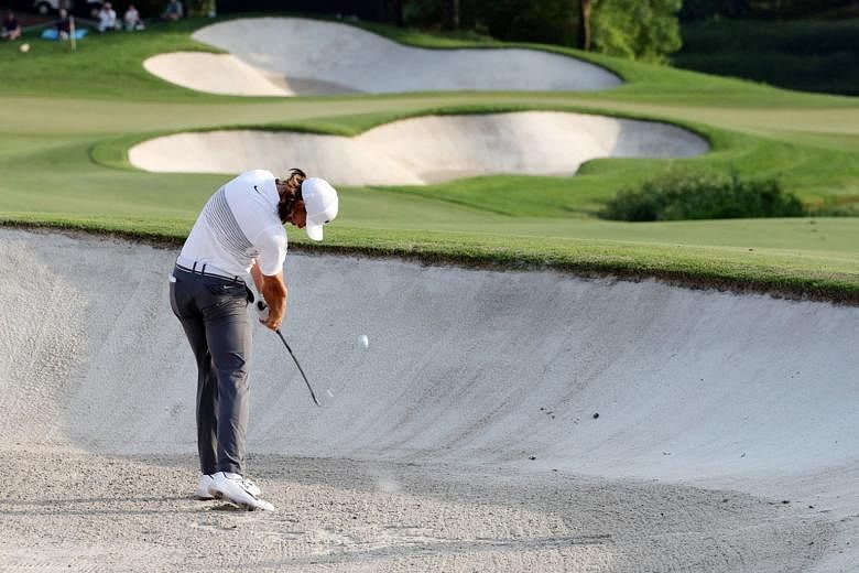 England's Tommy Fleetwood (above) playing a bunker shot during the first round of the DP World Tour Championship at Jumeirah Golf Estates in Dubai yesterday. The world No. 19 had a disastrous opening and handed Justin Rose (left) the initiative in th