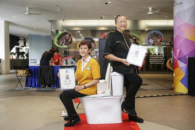 Cleaning assistants Tan Joo Hiang (left) and Yu Lee Wah with their Let's Observe Ourselves (Loo) Awards given by the Restroom Association (Singapore) yesterday.