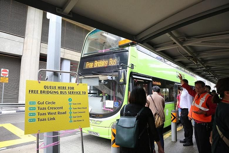 Commuters utilising the free bridging bus service at Joo Koon station yesterday morning. While the four stations on the extension - Gul Circle, Tuas Crescent, Tuas West Road and Tuas Link - will reopen after the weekend, the authorities will keep the