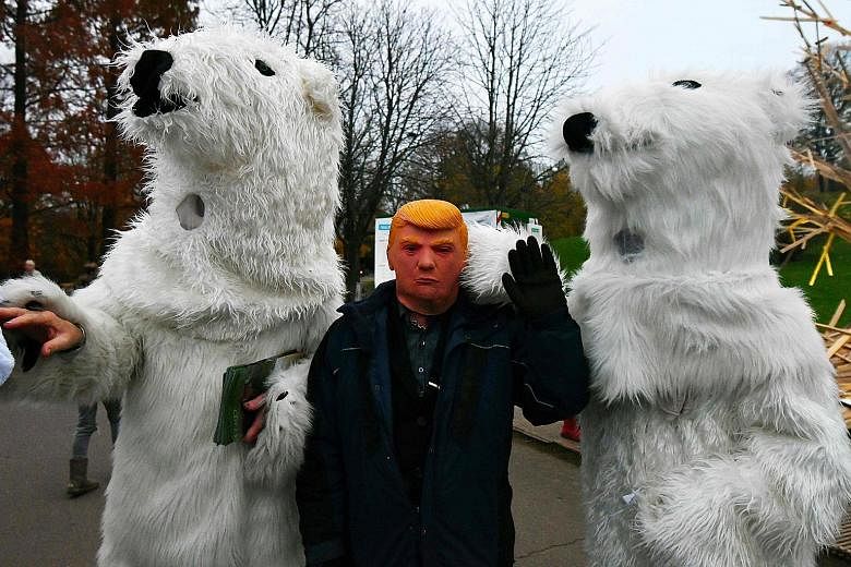 A man wearing a mask of President Donald Trump during the climate change conference in Bonn, Germany, on Thursday. Mr Trump's decision to withdraw the US from the global pact cast a shadow over talks.